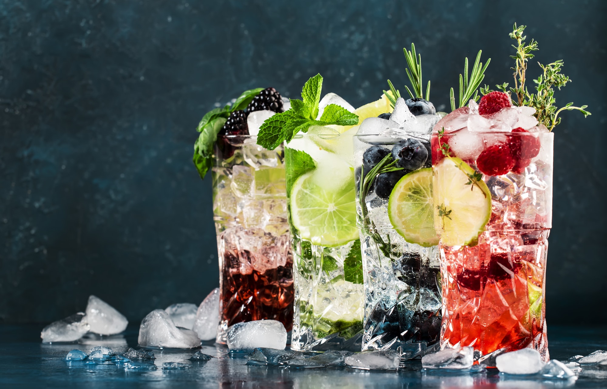 Cocktails drinks. Classic alcoholic long drink or mocktail highballs with berries, lime, herbs