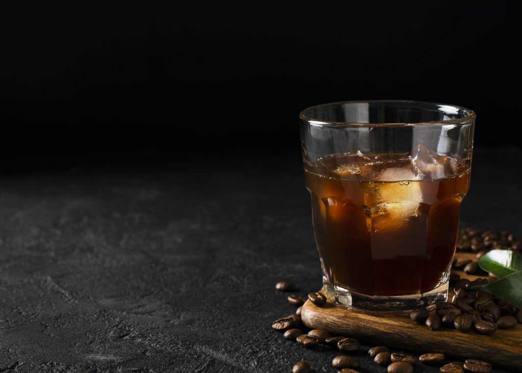 glass cold brew coffee with ice on black or dark background