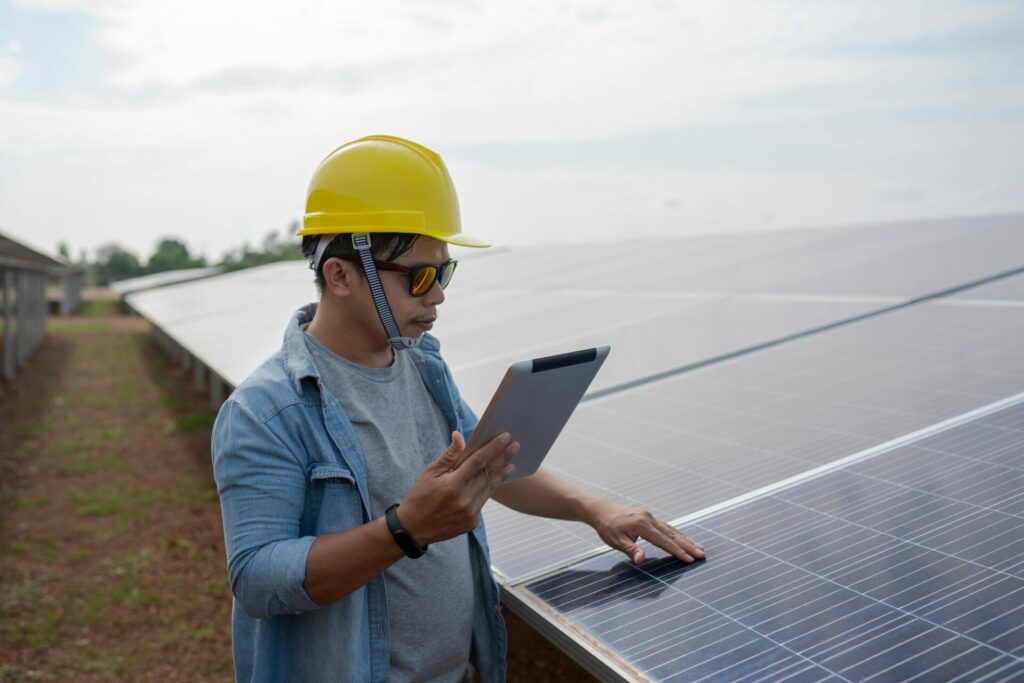 The technician uses a tablet to check the precision of solar energy to generate renewable energy.