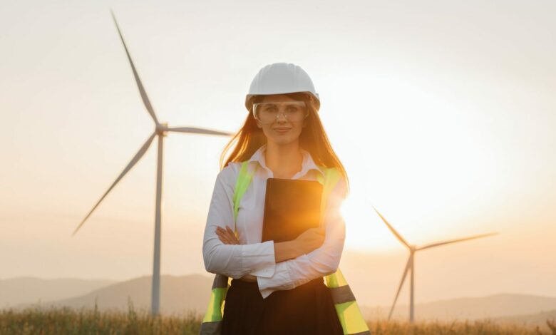 Woman in helmet working with tablet at renewable energy farm