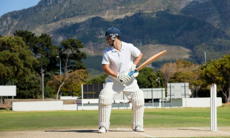 Batsman playing cricket on field against mountain