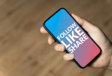 Follow Like Share - hand holding a phone
