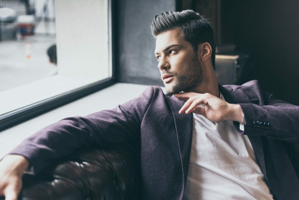 Portrait of handsome caucasian man with fashionable hairstyle at barber shop