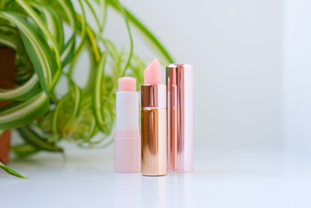 Scrub and balm in the form of lipstick. Delicate lip care. Simple minimalistic natural light photo.
