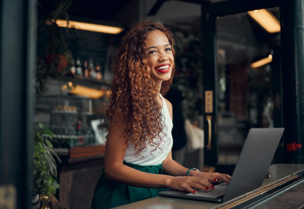 African woman, laptop and remote work at restaurant writing novel, digital content research or tech