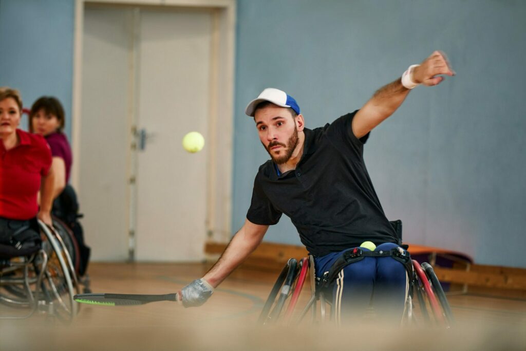 People in wheelchair playing tennis on court. Wheel Chair Tennis For Disabled.