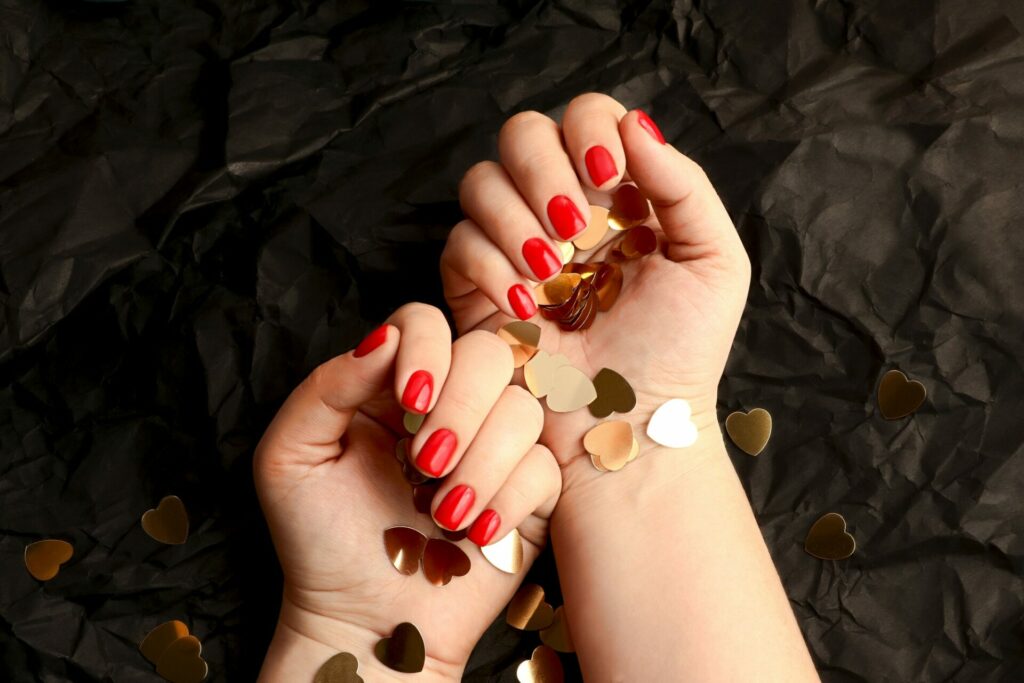 Red woman manicure on the art black background.