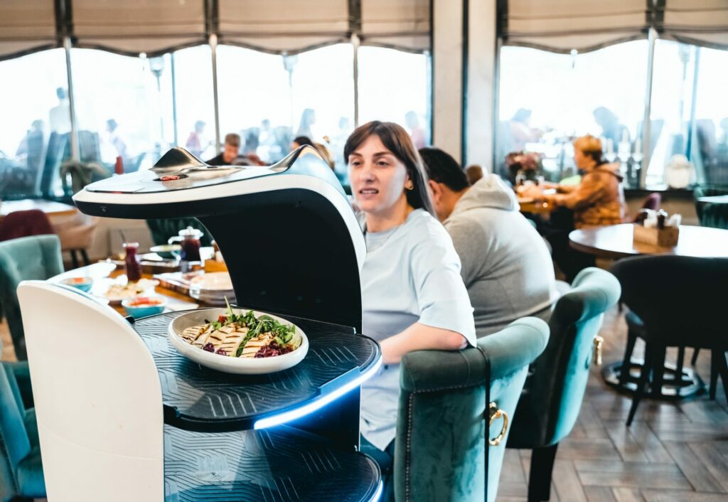 Robot waiter serve food at modern restaurant table.Offering innovation futuristic high-tech