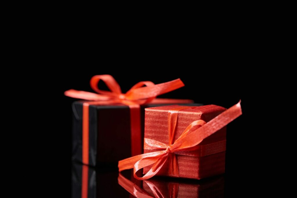 selective focus of black and red decorative gifts isolated on black