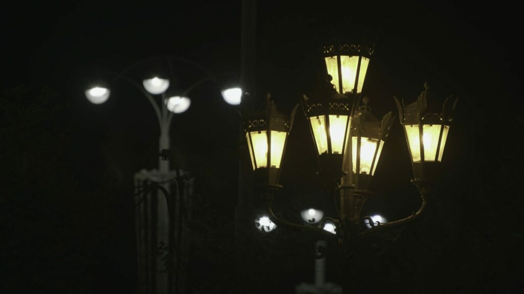 Two different street lanterns on black sky background. Stock footage. Old fashioned and modern