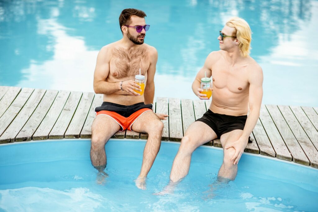 Two men sitting on the swimming pool outdoors