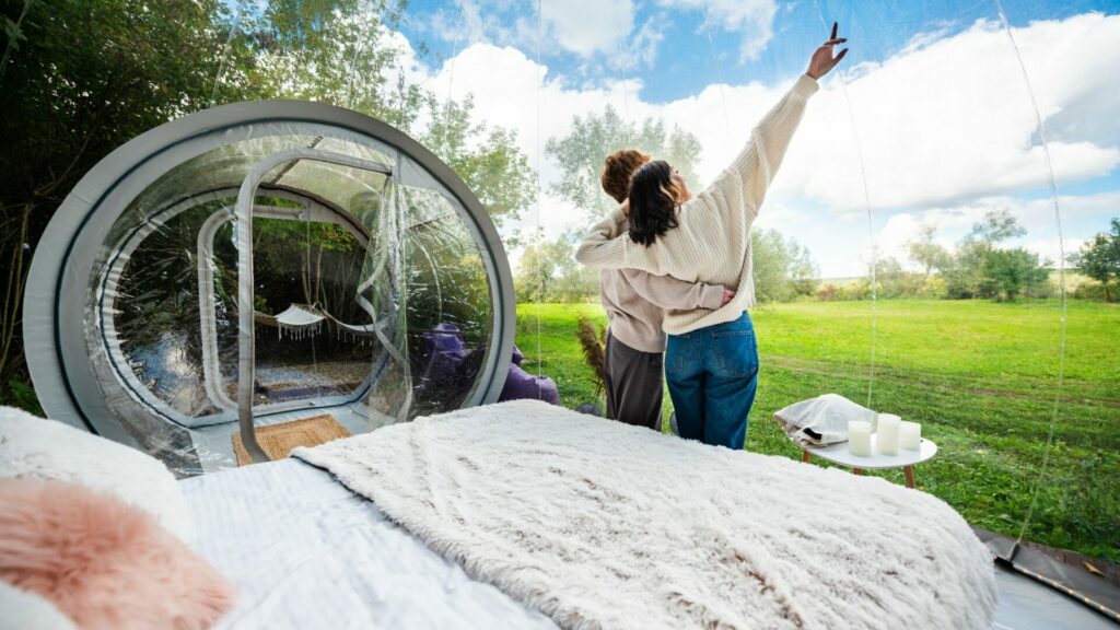 A couple inside a transparent bubble tent at glamping