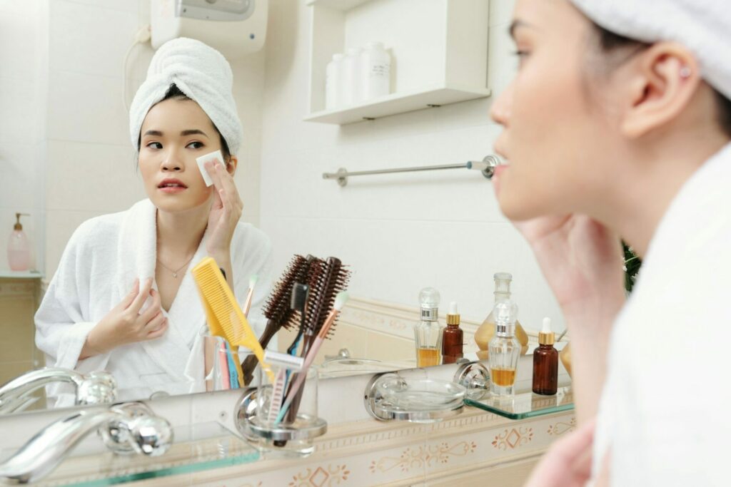 Woman applying skin toner to hide her combination skin