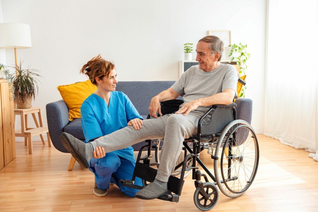 Young caregiver assisting senior man in wheelchair as he has availed assisted living services